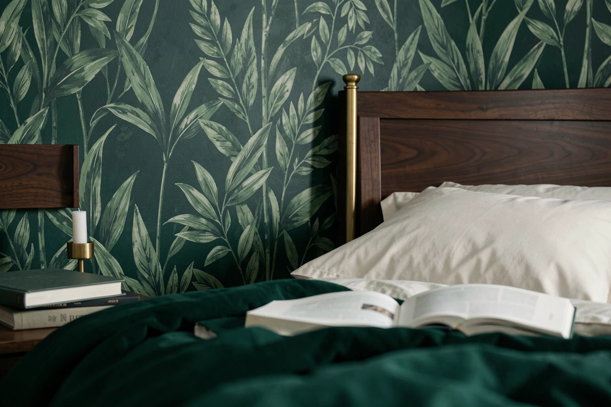 Détail de papier peint botanique vert forêt dans une chambre adulte cocooning avec tête de lit en noyer